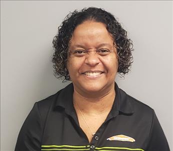 female employee with curly black hair, wearing a black shirt